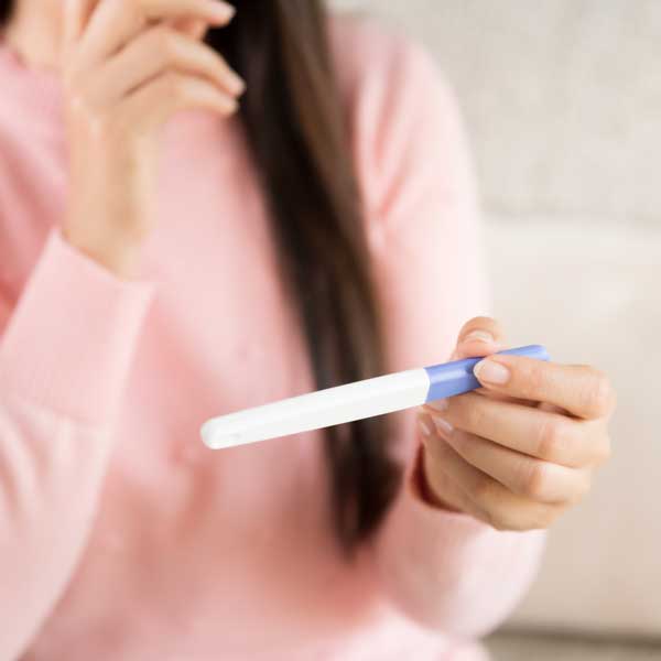 A woman looking at a pregnancy test result